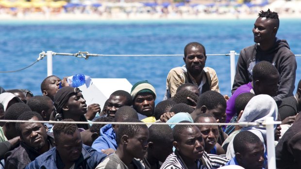 Migrants wait to disembark from a Coast Guard ship that rescued them at sea, on the Island of Lampedusa, Italy on Tuesday. About 2700 migrants were picked up on Monday trying to cross the Mediterranean.