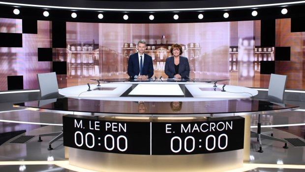 Journalists Christophe Jakubyszyn, left, and Nathalie Saint-Cricq show the where Macron and Le Pen will face off in a televised debate on Wednesday. 