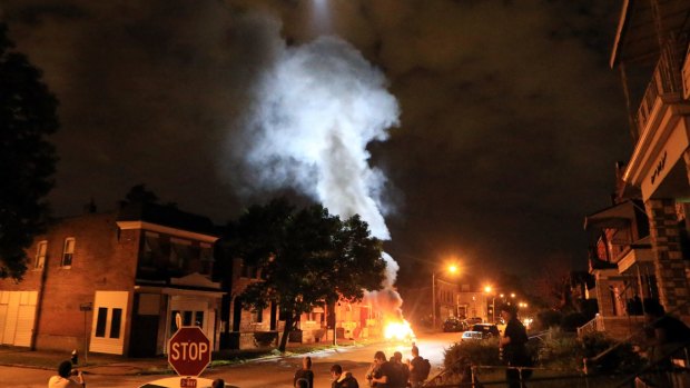A police helicopter illuminates a burning car in St Louis in August, after it was set ablaze following a fatal officer-involved shooting. A black 18-year-old fleeing from officers serving a search warrant at a home in a crime-troubled section of St. Louis was fatally shot by police after he pointed a gun at them, the city's police chief said. 