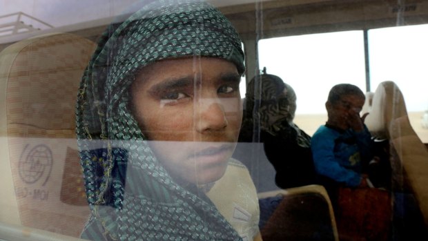 Syrian refugees wait on a bus after crossing into Jordan in Hadalat on the Syrian-Jordanian border on Wednesday.