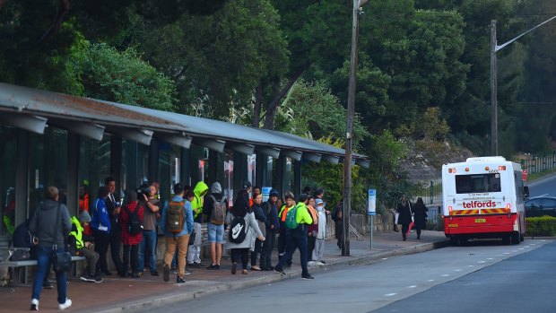 Commuters wait for a bus at Strathfield train station during the bus strike.