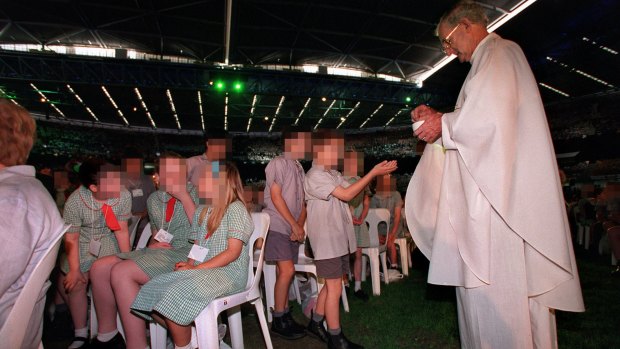 Father Joseph Doyle administers Mass to school children in 2000 at a huge celebration at the Docklands stadium in Melbourne.