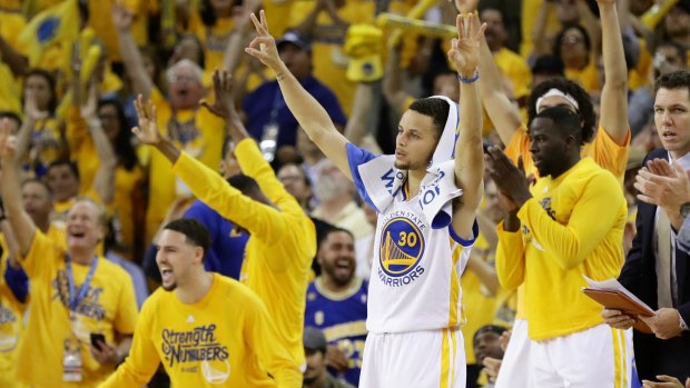 Victory salute: Stephen Curry and the bench of the Golden State Warriors react to a score against the Oklahoma City Thunder.