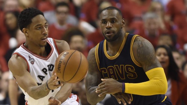 Dishing: Toronto Raptors guard DeMar DeRozan passes as Cleveland Cavaliers forward LeBron James looks on.