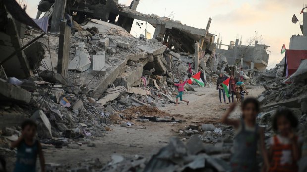 Palestinian children play near the ruins of their houses last year, destroyed during the seven-week Israeli offensive, in the devastated area in the east of Gaza City.