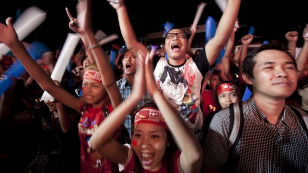 Supporters of Myanmar opposition leader Aung San Suu Kyi's National League for Democracy party cheer as they watch election results posted on an LED screen outside the party headquarters in Yangon on Monday. 