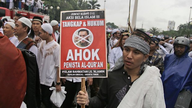 A man holds a poster during a rally against Jakarta's then governor Basuki "Ahok" Tjahaja Purnama, a Christian accused of blaspheming against Islam.