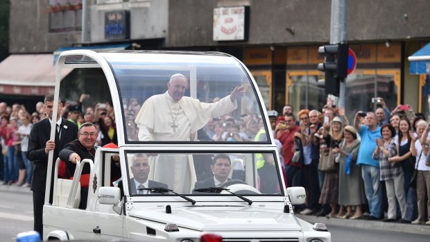 Pope Francis waves to the crowd from the popemobile on Saturday.