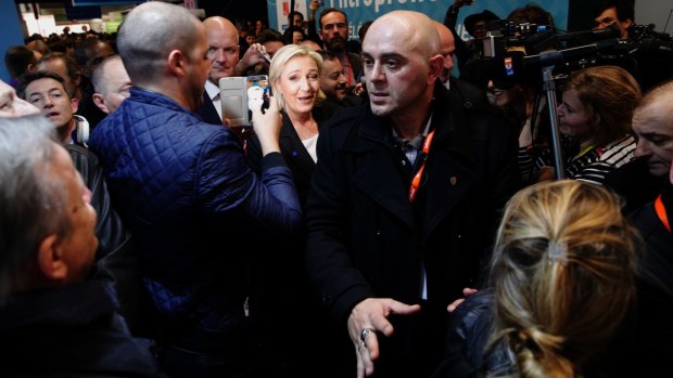 A reporter was ejected apparently at the request of a representative for Far-right leader and presidential candidate Marine Le Pen, centre.