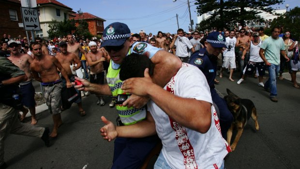 Terrible scenes: A police officer shields a man during the infamous Cronulla riots of 2005.