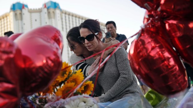 Christine Torres, right, and her daughter Sydney hug at a memorial for the shooting victims in Las Vegas on Tuesday.