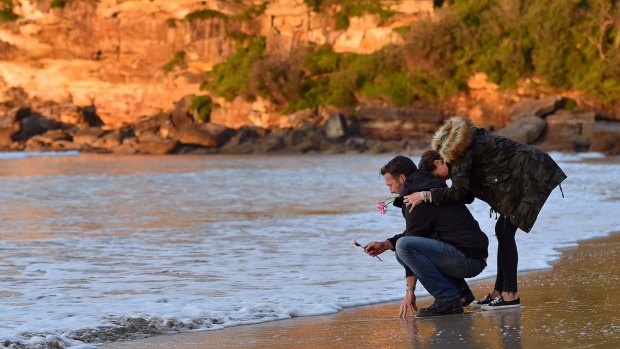 Heartbroken: Justine Damond's brother, Jason Ruszczyk with his wife, Katarina Ruszczyk, at the water's edge at Freshwater Beach during a vigil on Wednesday.