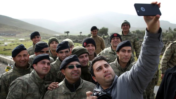 A Turkish journalist takes a selfie with Turkish soldiers on the border with Syria on Monday. Operation Olive Branch on the Kurdish enclave of Afrin started on Saturday.