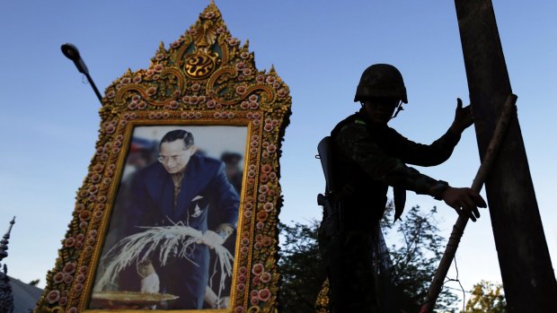 A soldier in front of a picture of Thailand's King Bhumibol Adulyadej amid anti-government protests in central Bangkok in May 2014.