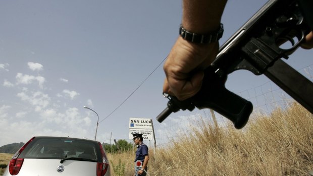 An Italian police officer holds a sub-machine gun at a roadblock near San Luca, a Calabrian town notoriously known as an organised crime stronghold. 