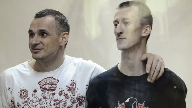 Solidarity ... Ukrainian film director Oleg Sentsov (left) and activist Alexander Kolchenko look on from a defendants' cage as they attend a court hearing in Rostov-on-Don, Russia.