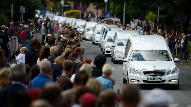 Students from the Joseph-Koenig-Gymnasium high school watch as hearses carrying the remains of 16 of their fellow students and two teachers who were killed in the Germanwings crash drive past on June 10 this year in Haltern am See, Germany.  