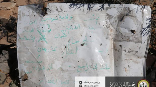 A poster with partially-erased Arabic slogans supporting the Islamic State group found at the site where US warplanes struck.