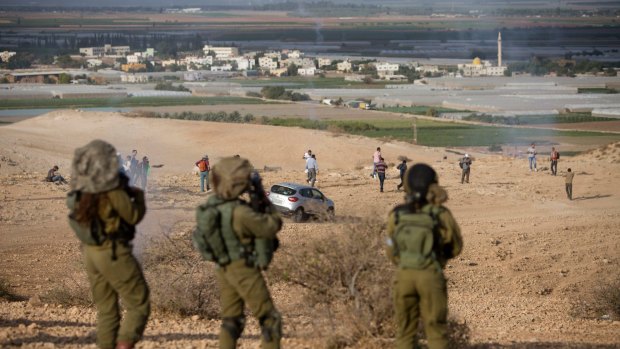 Palestinians and Israeli activists run away from tear gas fired by Israeli soldiers during a demonstration against the construction of Jewish settlements in the Jordan Valley, in the West Bank in November.
