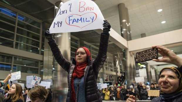 Demonstrators hold signs and chant in the baggage claim area during a protest at Detroit Metropolitan Airport. 