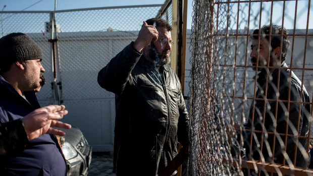 Men wanting to return to Syria waits in line to pass through a border gate on Mohday,  in Kilis, Turkey.