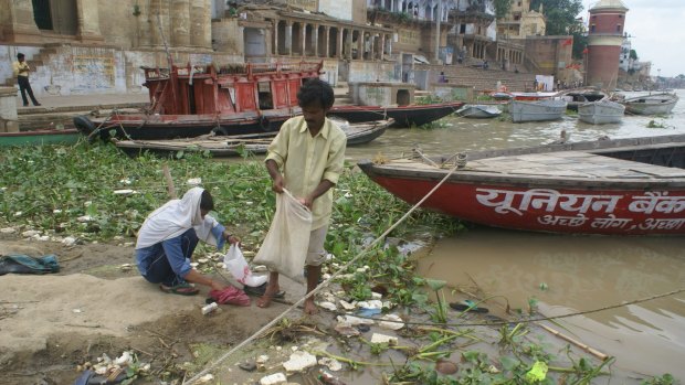 People pick through rubbish at a section of the Ganges near the ghats at Varanasi.