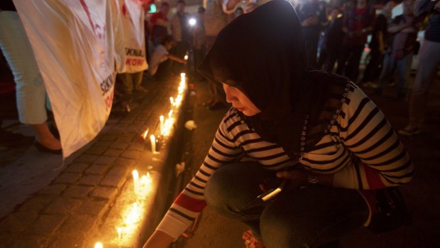 An Indonesian woman lights candles near the site of the January 14 attacks.