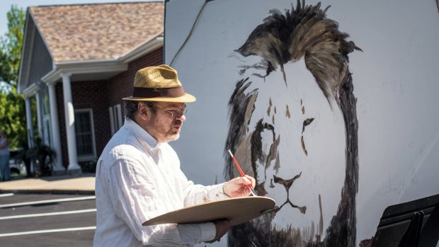 Artist Mark Balma paints a mural of Ceci outside Walter Palmer's office in Bloomington, Minnesota, on Wednesday. 