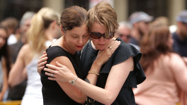 Women comfort each other in Martin Place this week.