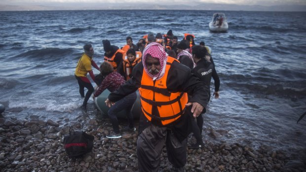 An Iraqi man disembarks from a dinghy on a beach after his trip with other refugees  from the Turkish coast to the Greek island of Lesbos on Friday. Thousands of migrants continue to risk the same dangerous journey.