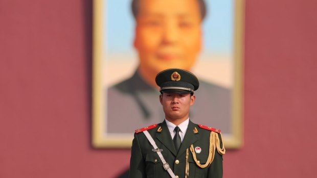 A guard stands in front of the portrait of Chairman Mao at Tian'anmen Square
