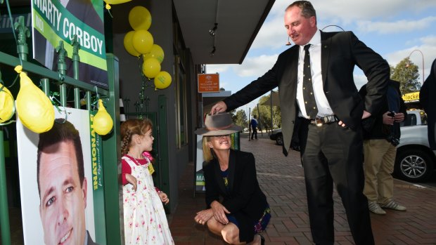 Marty Corboy's daughter Bridget Corboy, 4, watches National Party leader Barnaby Joyce put his country hat on Fiona Nash.