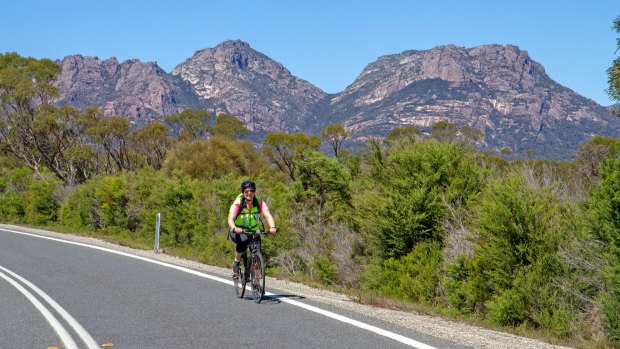 Cycling on Frecyinet Peninsula, with the Hazards mountains behind.