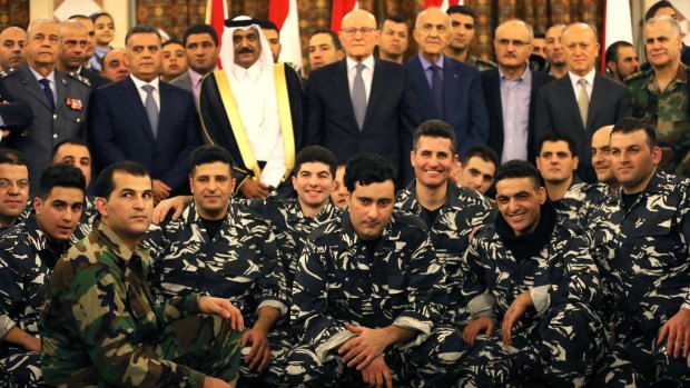 The released Lebanese policemen and soldiers with Lebanese and Qatari officials at the government palace in Beirut.