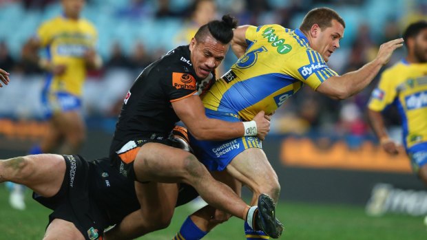 Western derby: Parramatta forward Danny Wicks is tackled by Wests Tigers rival Sauaso Sue.