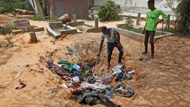 Afrah Ibrahim, centre, searches through the clothes of the dead for a clue to his missing sister outside a hospital in Mogadishu.