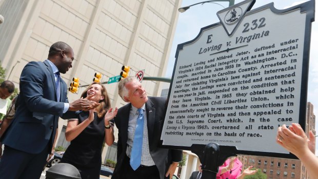 Virginia governor Terry McAuliffe , right, looks over a historical marker for the Lovings, along with his wife, Dorothy, centre, and Richmond mayor Lavar Stoney, left.