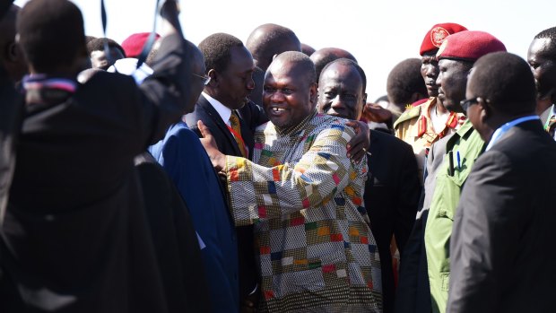Former Vice-President Reik Machar is greeted by officials after touching down in Juba.