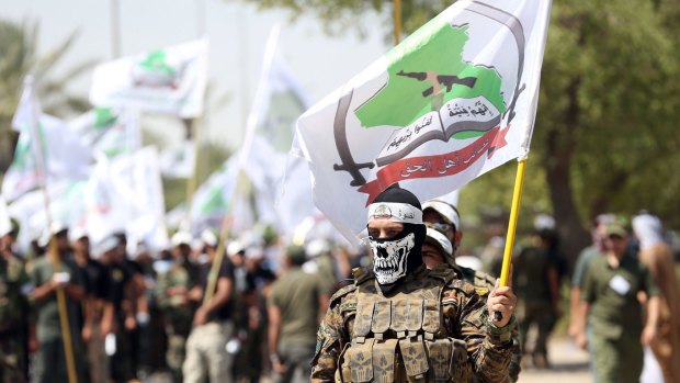 Members of the Shiite group Asaib Ahl al-Haq march in Baghdad in July.