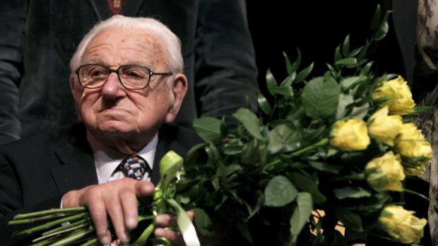 Nicholas Winton, aged 101, holds flowers while sitting on a stage after the premiere of the movie 'Nicky's family' which is based on his life story in Prague.
