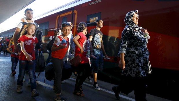 Travellers believed to be migrants leave a train coming from Hungary at the railway station in Vienna on Monday.