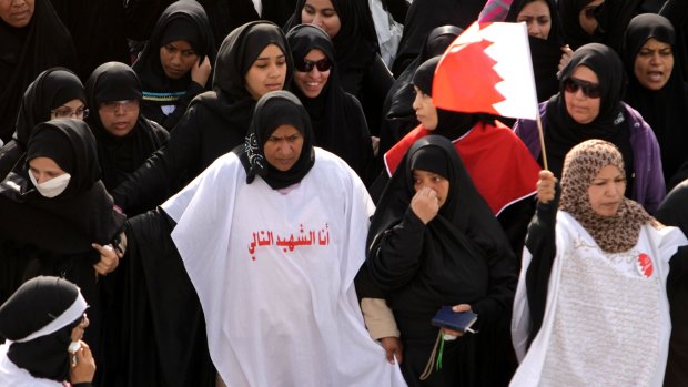 Anti-government protesters carry Bahraini flags during a march of thousands in 2011.