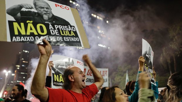 Demonstrators hold signs that reads in Portuguese "No Prison for Lula, down with the coup," during a protest on Wednesday against the decision to convict the former president for corruption and money laundering.