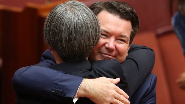 Senator Penny Wong is hugged by co-sponsor Senator Dean Smith after speaking on the Marriage Amendment Bill at Parliament House in Canberra.