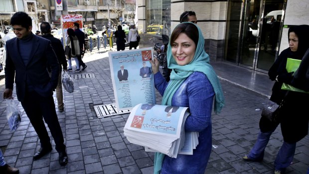 An Iranian election campaign worker distributes electoral leaflets of reformist candidates in downtown Tehran.