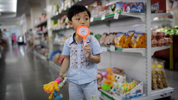 A boy stands in the aisle at the Potonggang department store in Pyongyang, North Korea. Three generations into Kim Jong-un's ruling dynasty, a consumer culture is taking root. 
