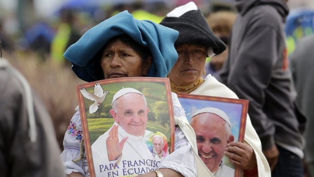 Otavalenas Indians holding posters featuring Pope Francis arrive at Bicentennial Park to attend a Mass celebrated by the pontiff, in Quito, Ecuador.