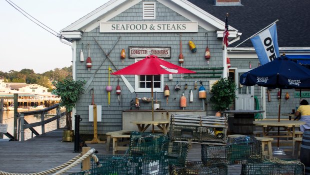 Lobster traps drying in front of a seafood restaurant on the harbour in Boothbay, Maine. 