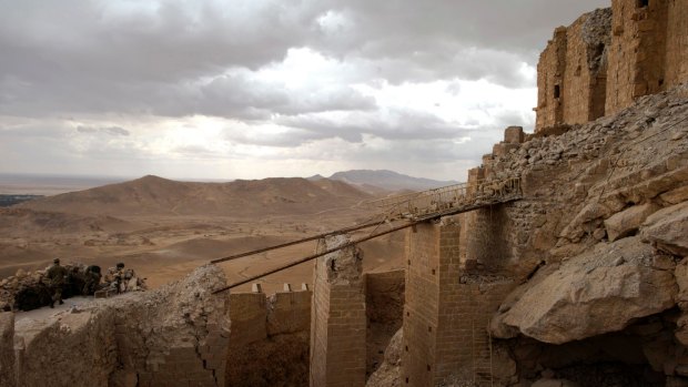 Russian soldiers, left, stand guard next to what remains of the Palmyra citadel.