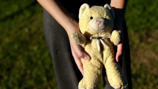 Jamee-Lea Fraser, 15, holds a teddy bear that was retrieved from the house after a bulldozer flattened it.